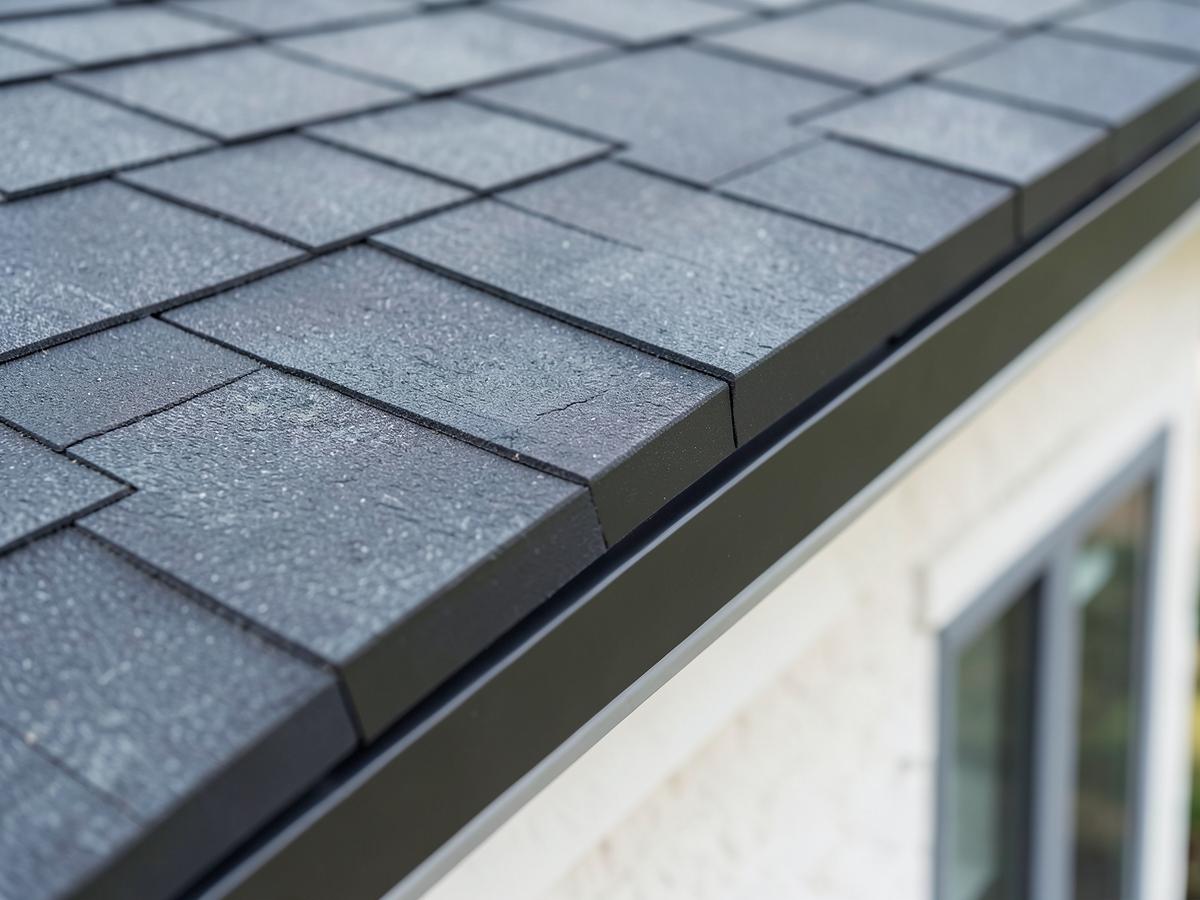 Sample close-up of charcoal asphalt shingles on a residential roof